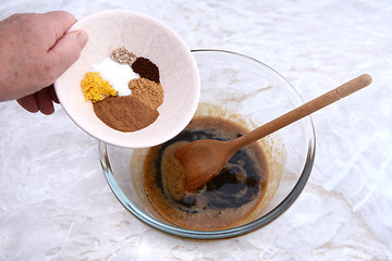 Image showing Woman adding spices to pumpkin pie filling