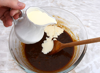 Image showing Pouring cream into pumpkin pie filling