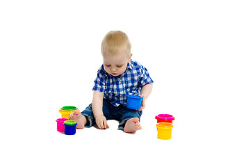 Image showing little boy in checkered shirt plays on the floor. Studio