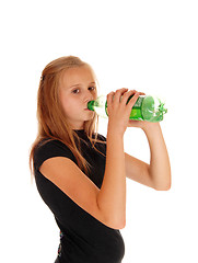 Image showing Girl drinking pop from bottle.