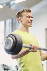 Image showing smiling man doing exercise with barbell in gym