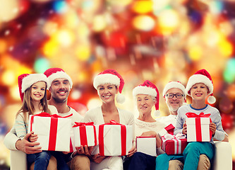 Image showing happy family in santa helper hats with gift boxes