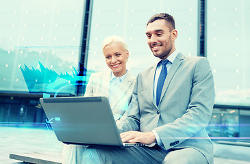 Image showing smiling businesspeople with laptop outdoors