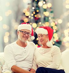 Image showing happy senior couple in santa helper hats