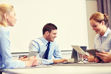 Image showing smiling business people with tablet pc in office