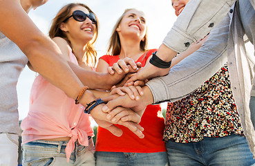 Image showing close up of happy friends with  hands on top 