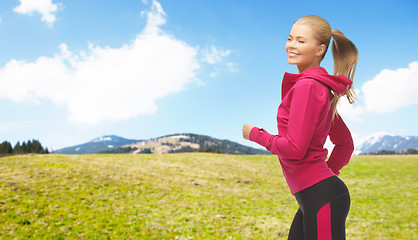 Image showing happy sporty woman running or jogging outdoors