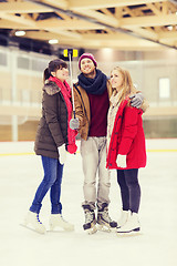 Image showing happy friends taking selfie on skating rink