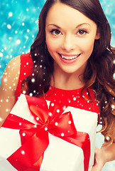 Image showing smiling woman in red dress with gift box