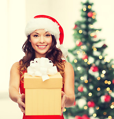 Image showing smiling woman in santa helper hat with gift box