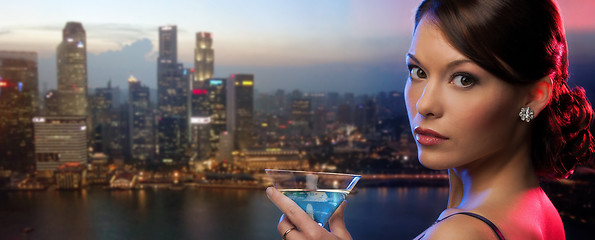 Image showing woman holding cocktail over singapore night city