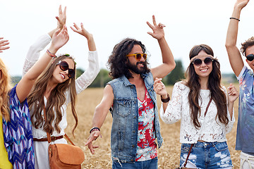 Image showing happy young hippie friends dancing on cereal field