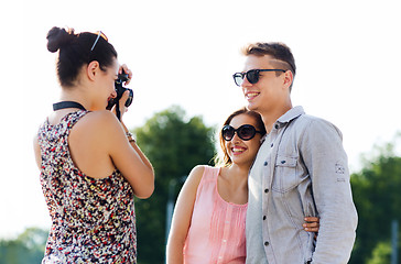 Image showing happy friends with camera taking picture outdoors