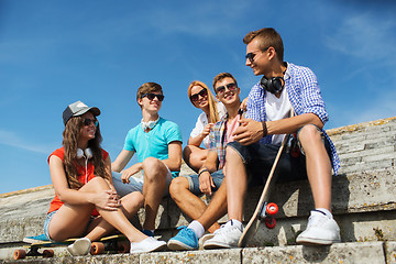 Image showing happy teenage friends with longboard on street