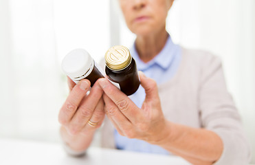 Image showing close up of senior woman with medicine jars