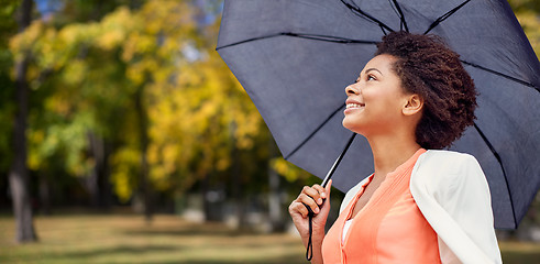 Image showing happy african woman with umbrella in autumn park 