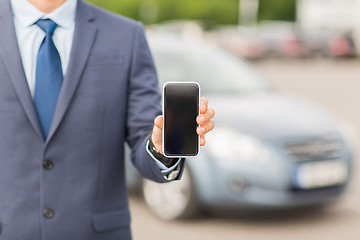 Image showing close up of business man with smartphone and car