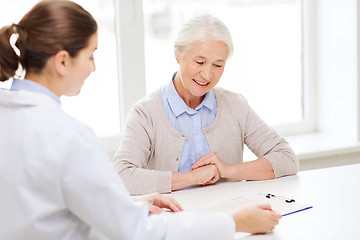 Image showing doctor with clipboard and senior woman at hospital