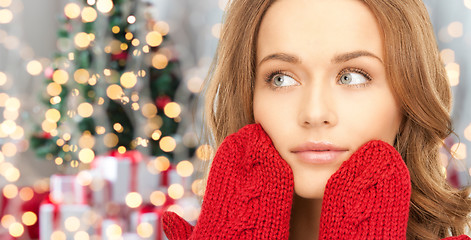 Image showing happy woman in red mittens over christmas lights