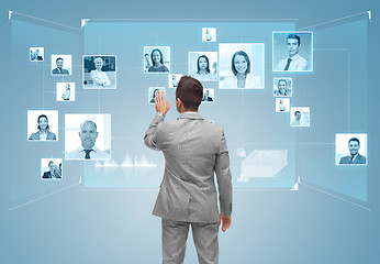 Image showing businessman with contacts icons on virtual screen