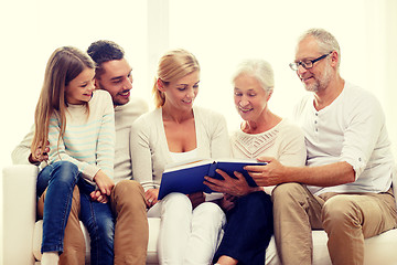 Image showing happy family with book or photo album at home