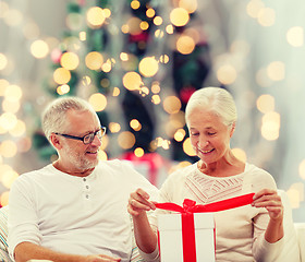 Image showing happy senior couple with gift box at home