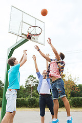 Image showing group of happy teenage friends playing basketball