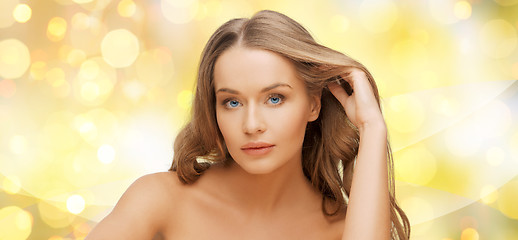 Image showing beautiful young woman face over yellow lights