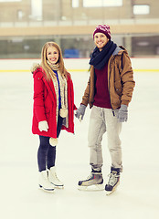 Image showing happy couple holding hands on skating rink