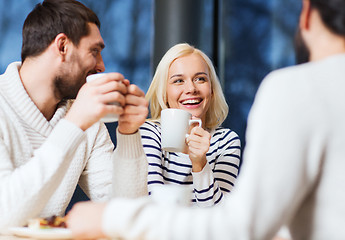 Image showing happy friends meeting and drinking tea or coffee