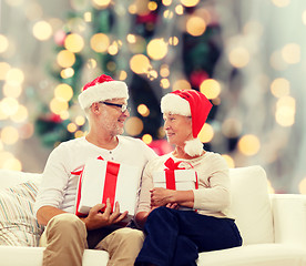 Image showing happy senior couple in santa hats with gift boxes