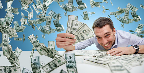 Image showing happy businessman with heap of money