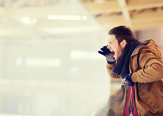 Image showing young man supporting hockey game on skating rink