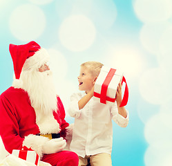 Image showing smiling little boy with santa claus and gifts