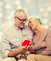 Image showing happy senior couple with red gift box