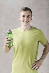 Image showing smiling man with bottle of water in gym