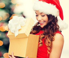 Image showing smiling woman in santa helper hat with gift box