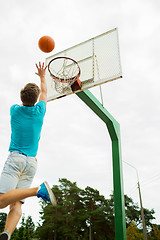 Image showing young man playing basketball outdoors