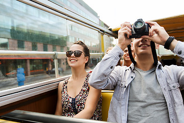 Image showing smiling couple with camera traveling by tour bus