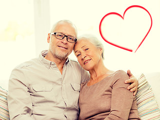 Image showing happy senior couple hugging on sofa at home