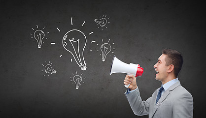 Image showing happy businessman in suit speaking to megaphone