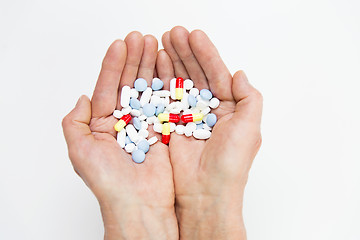 Image showing close up of senior woman hands with pills