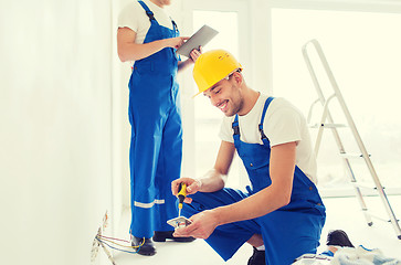 Image showing builders with tablet pc and equipment indoors