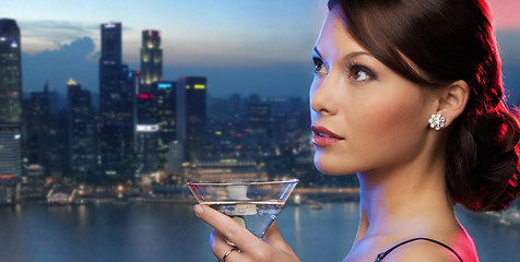 Image showing smiling woman holding cocktail over night city