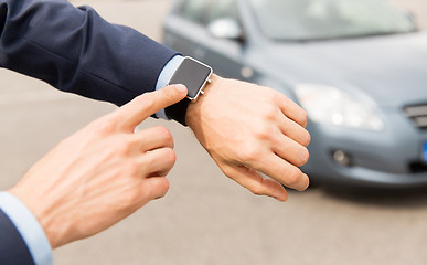 Image showing close up of male hands with wristwatch and car