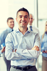 Image showing smiling businessman with colleagues in office