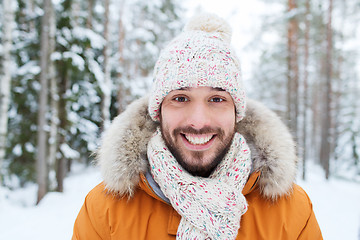 Image showing smiling young man in snowy winter forest