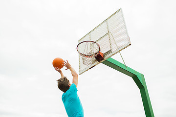 Image showing young man playing basketball outdoors