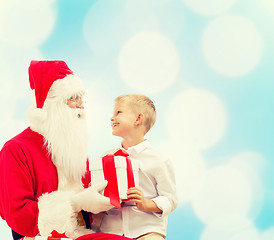 Image showing smiling little boy with santa claus and gifts