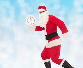 Image showing man in costume of santa claus with clock